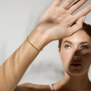 Image d'un bracelet en or véritable porté par une femme, mettant en lumière son design raffiné et sa durabilité.