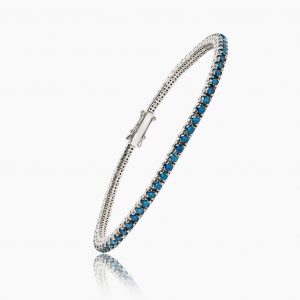 Bracelet en or blanc serti de saphirs bleus, symbole de luxe et sophistication.