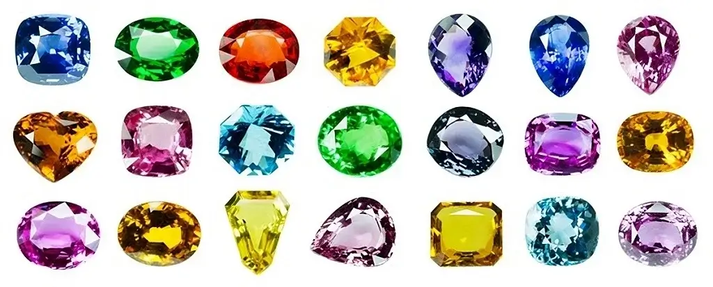 Une collection variée de pierres précieuses et semi-précieuses, incluant rubis, émeraudes, saphirs et citrines, aux couleurs vibrantes.